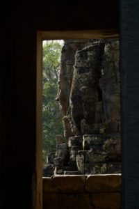 Visages de pierre du Bayon vu à travers une porte