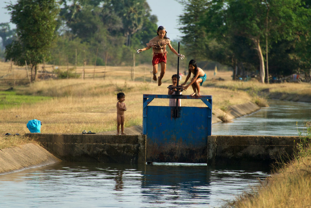Gamins jouant dans le canal d'irrigation des rizières